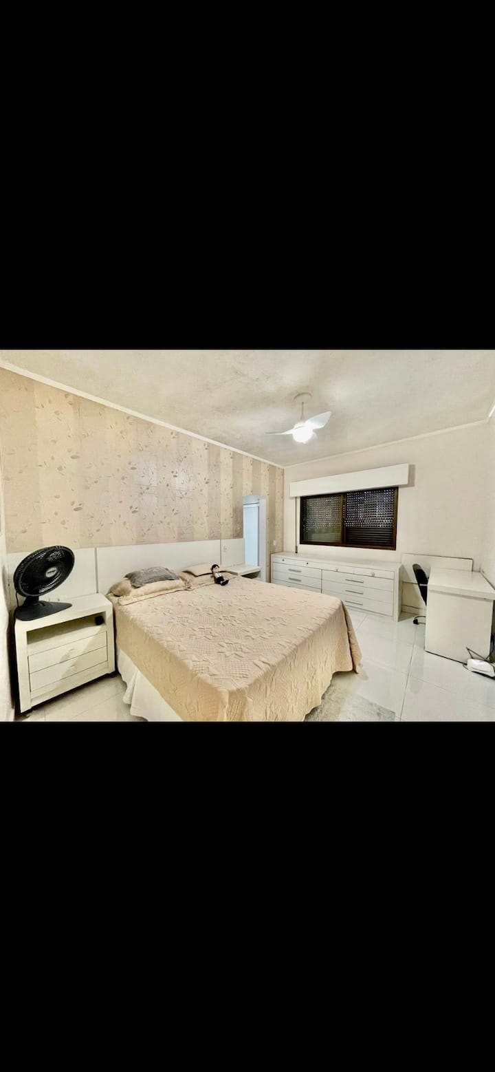 Chumba chenye vyumba viwili na televisheni, kabati, kiyoyozi, feni ya dari na kitanda cha malkia.