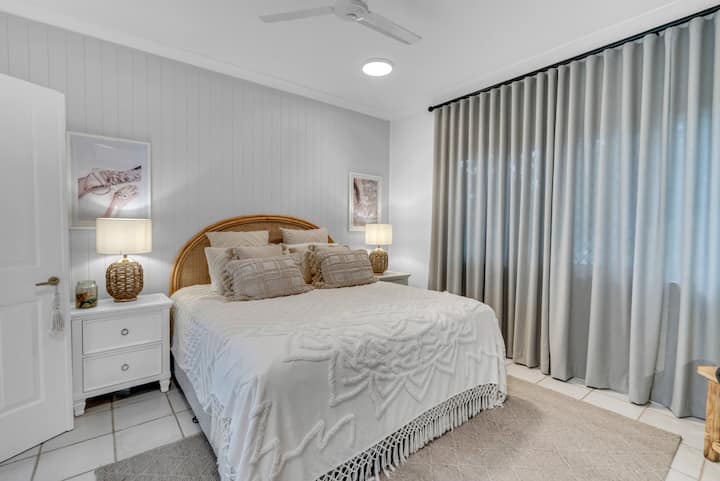 غرفة نوم رئيسية جميلة مع سرير بمقاس كبير وحمام داخلي وتلفزيون سوني ذكي مثبت على الحائط