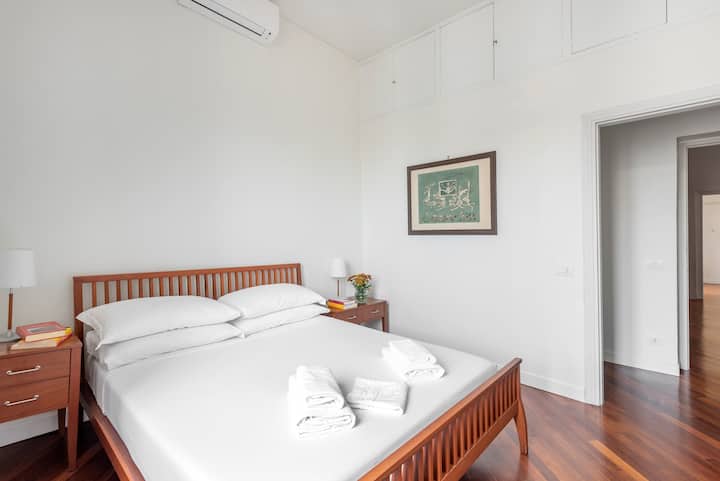 Chumba cha kulala kilicho na kitanda cha watu wawili, kilicho na mashuka safi, meza za kando ya kitanda, taa, makabati na kiyoyozi.