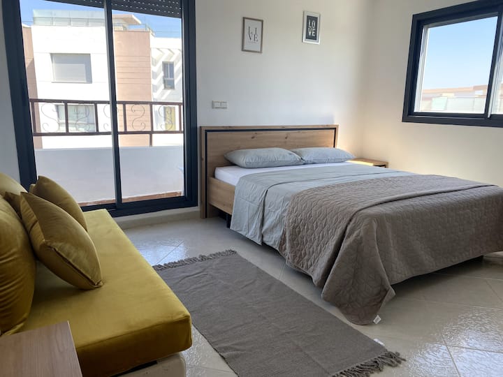 Bedroom 1 with wardrobe and seating area overlooking the terrace