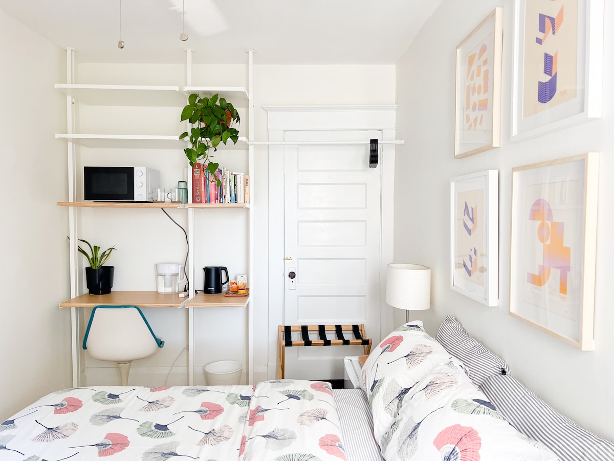 זהו חדר השינה של האורחים של Airbnb עם טלוויזיה עם נטפליקס, שולחן כתיבה, מיקרוגל, כלים, מיטה זוגית, דוכן מזוודות, מקום לתליית בגדים, שולחן כתיבה וחדר רחצה צמוד פרטי עם שירותים, מראה גדולה ומקלחת. 