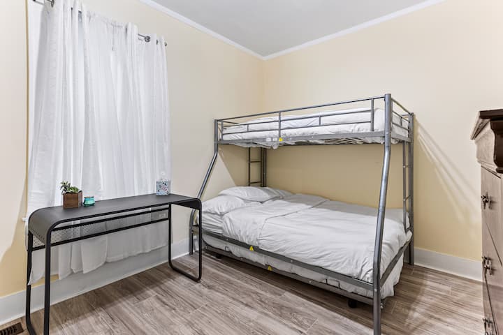 El dormitorio 2 incluye una litera con una litera inferior de tamaño completo, una litera doble y una cama nido corrediza doble para alojar a 4 huéspedes. Este dormitorio también incluye un espacio de trabajo dedicado, una cómoda alta para guardar y un armario corredizo con puerta de granero.