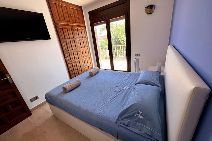 Habitació amb llit queen de 150x200cm. Equipat amb televisor i ventilador de terra.