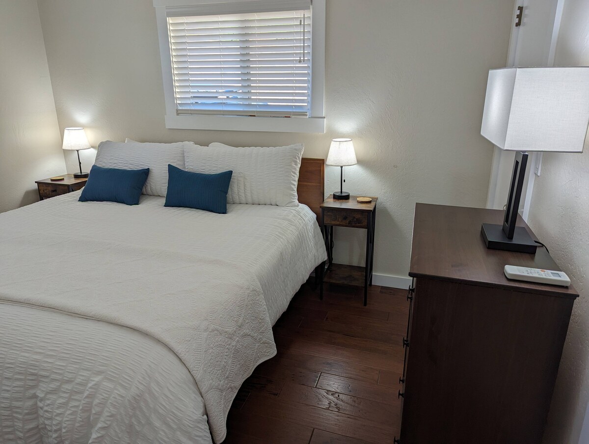 Ნათელი და მზიანი საძინებელი დიდი ზომის საწოლით, კომოდითა და კარადით.