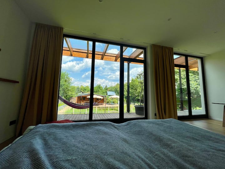 Dormitorio 1 (cama: 200 x 200) y vistas al jardín y hamaca. 