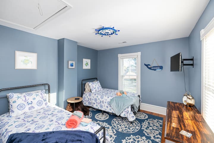 Მეორე სართული საძინებელი ორი ერთადგილიანი საწოლით და როკუს ტელევიზორით.  