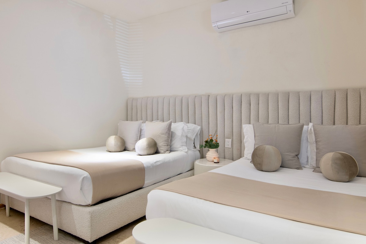 Un remanso de comodidad y elegancia: sumérgete en la tranquilidad de dos camas tamaño queen con colchón de calidad hotelera y ropa de cama de lujo. Desde los muebles meticulosamente diseñados hasta cada detalle considerado, ofrecemos una estancia sumamente cómoda. 