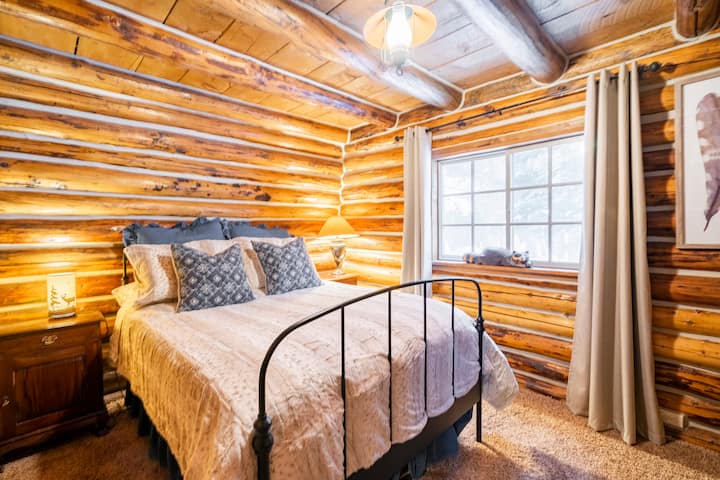 Bedroom 2 has a cozy double bed with memory foam topper surrounded by the original log walls.