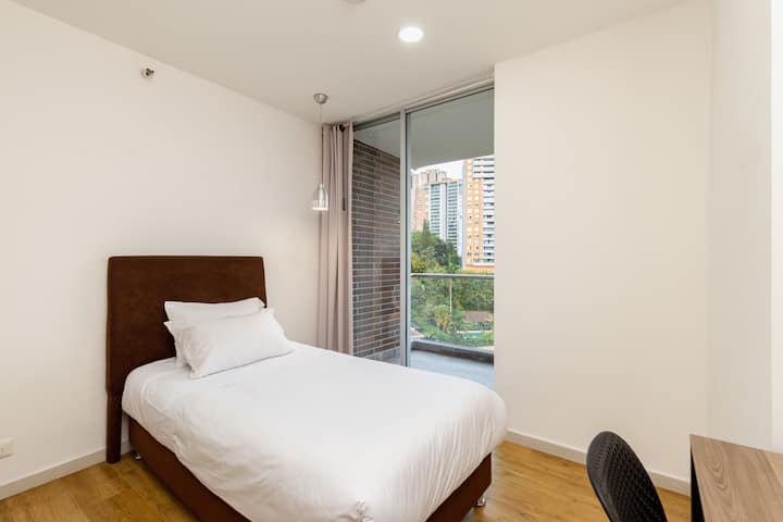 La cama de esta habitación es para una persona y tienes acceso directo al balcón del apartamento.