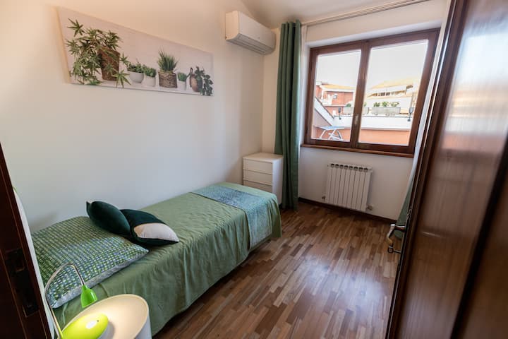 Единечна спална соба (на горниот кат) со клима уред и поглед кон терасата за сончање.