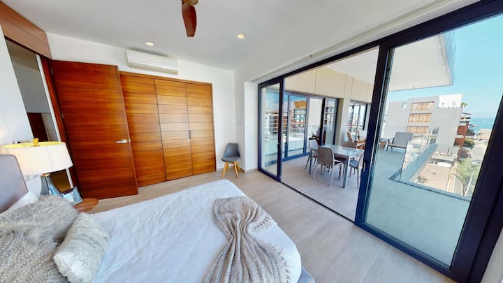 Bienvenido a nuestra lujosa habitación de invitados con otra cama tamaño king, amplio espacio de almacenamiento y acceso a una terraza privada. Disfruta de un café al sol o relájate con las vistas nocturnas del océano. (Imagen anterior con cama tamaño queen/mostrada para acceso a la terraza y vistas)