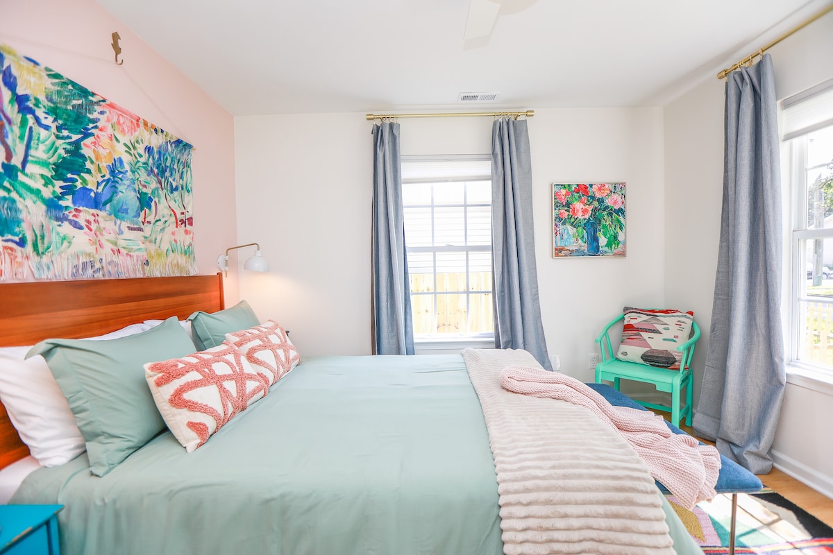 Primary suite with queen bed, desk area, and blackout curtains