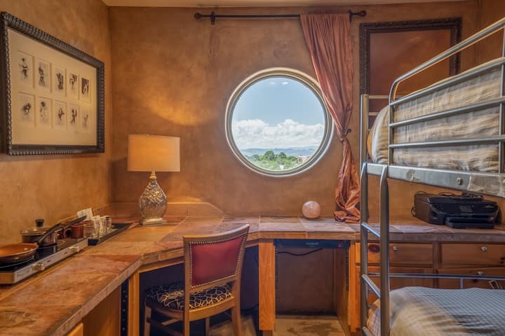 חדר שינה רביעי עם מיטות קומתיים כפולות עם שולחן עבודה גדול עם נוף לשקיעה. 