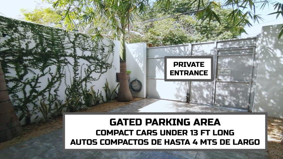 A gated parking area is shown, designed for compact cars under 13 feet in length. The entrance is private and surrounded by greenery, providing a secure space for vehicle storage.