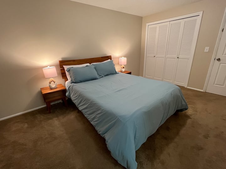 Dormitorio principal con cama tamaño queen, armario grande y baño privado con ducha.