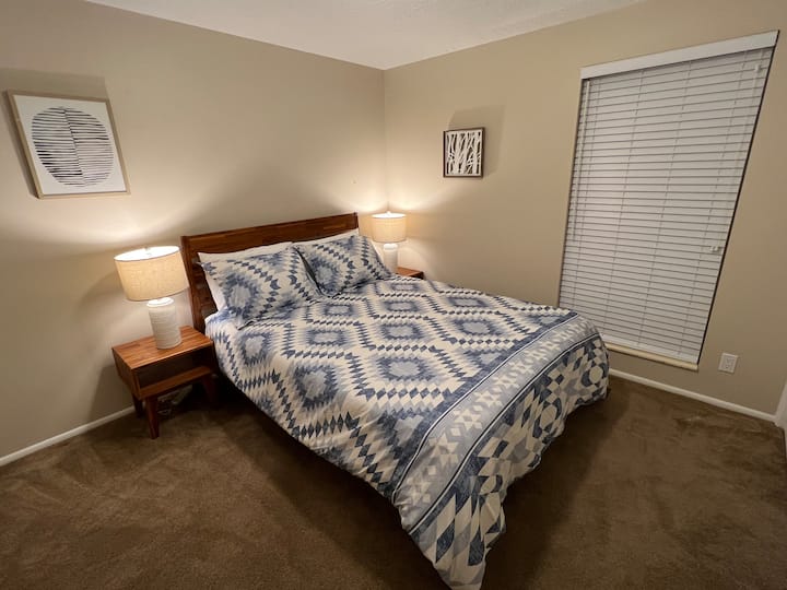 Dormitorio secundario con cama tamaño queen y armario grande.