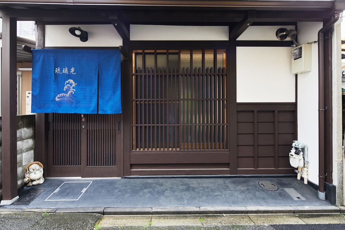 瑠璃光民宿 - 青い暖簾と伝統的な京町屋の正面