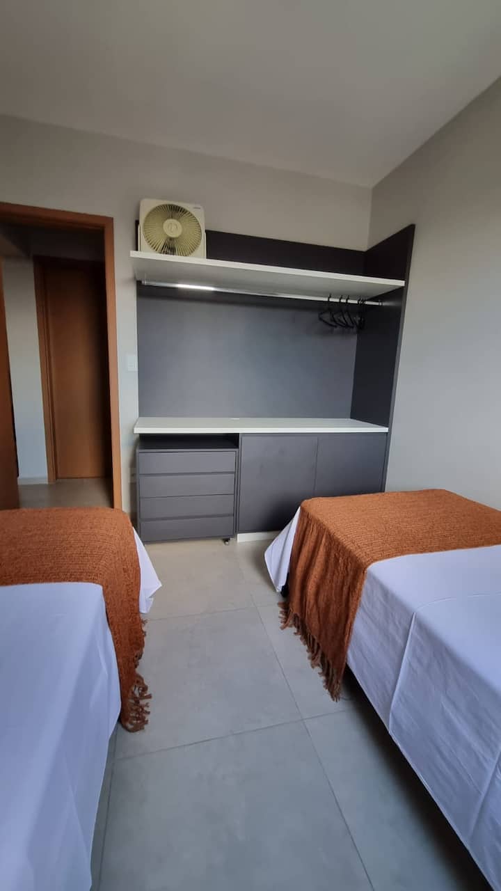 La habitación individual ofrece dos cómodas camas, perfectas para  profesionales que buscan un espacio versátil y práctico, con armario, escritorio de trabajo proporcionado por el cajón móvil y la torre de enchufe para cargar y conectar sus dispositivos.