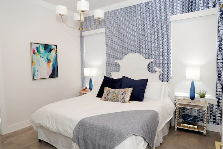 Relax in serene luxury in the indigo blue-themed bedroom. A king-sized bed invites you to unwind, while a TV provides entertainment. The ensuite bathroom offers modern convenience, completing your private oasis for a perfect nights rest. 