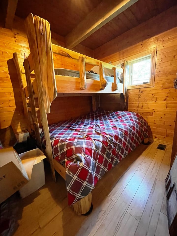 Kitanda cha ghorofa kilicho na kitanda cha ukubwa wa malkia kwenye sehemu ya chini na kitanda cha ukubwa wa mapacha juu.