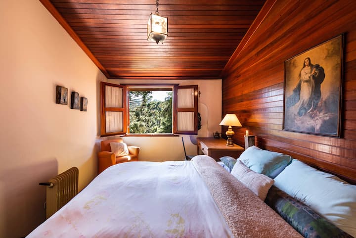 Suite avec lit Queen Size, placard, bureau et fauteuil.