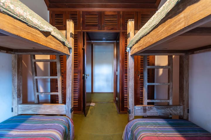 Chambre 2 de la maison principale : deux lits superposés, table d'appoint et placard.