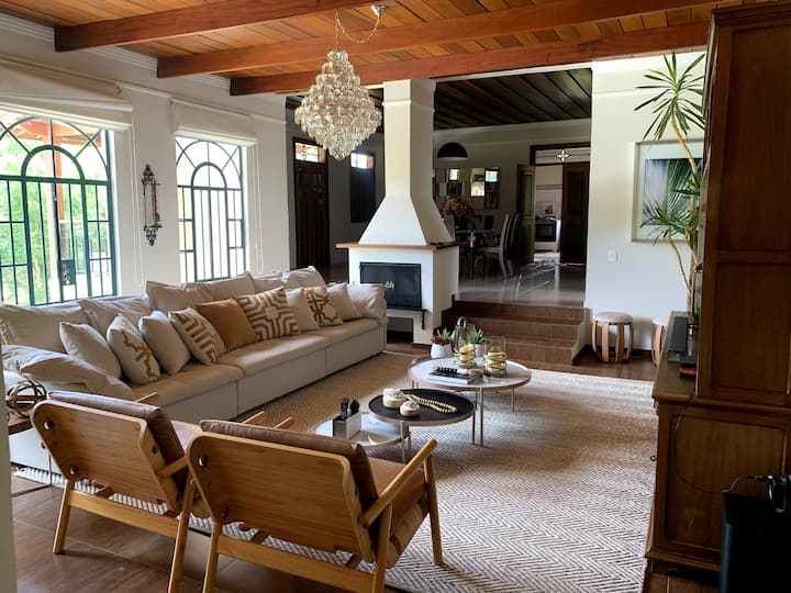 ห้องหลักพร้อมโซฟาเครื่องปรับอากาศเตาผิงวิวสระว่ายน้ำและทีวีพร้อมแอพ