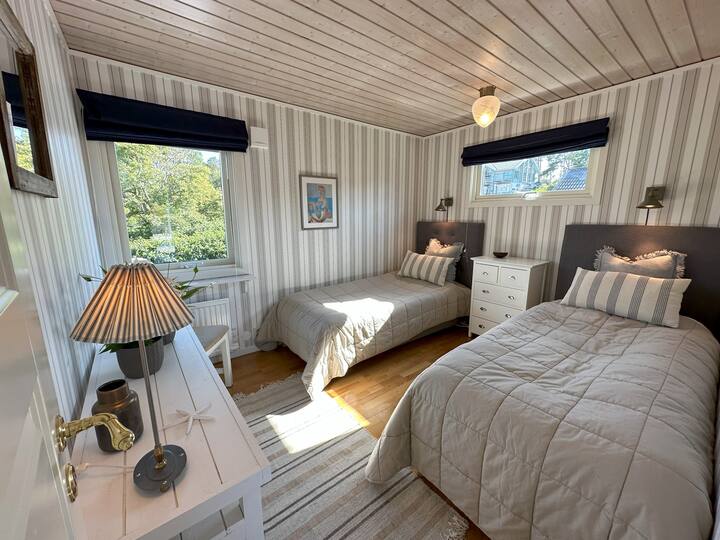 Bella camera da letto con due letti singoli larghi 90 cm con grandi fondi a molle e materassi spessi.