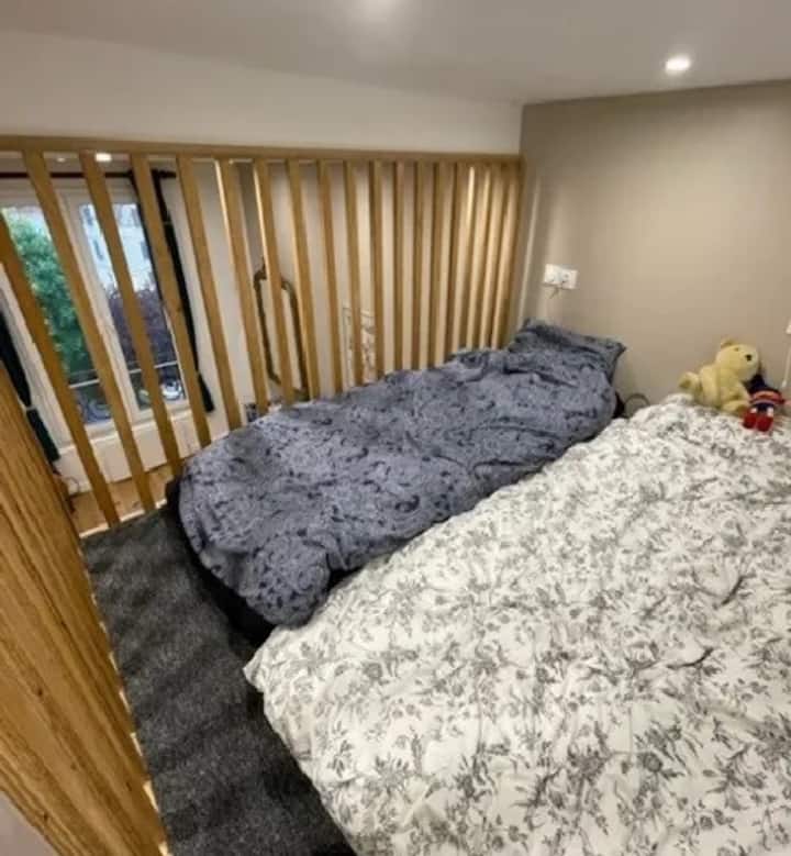 Ამ ფოტოზე: ანტრესოლი მისაღებ ოთახში, რომელზეც ხის კიბეა. Ძალიან დაცული სივრცე, სადაც ორი ერთადგილიანი ლეიბი, შესანიშნავი ხარისხის , დამონტაჟებულია ორი ადამიანის დასაძინებლად. 