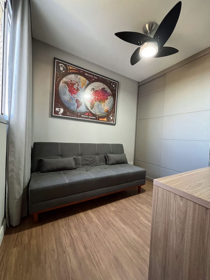 Ofisi iliyo na kitanda cha sofa na feni ya dari