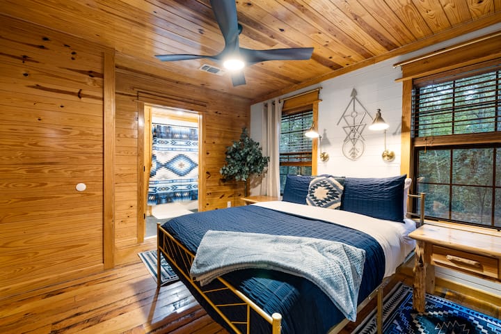 Our "blue" bedroom has an attached on-suite primary bathroom and two sconce reading lights by the bed for easy reading.