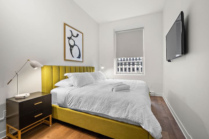 Duerme profundamente en un dormitorio sereno con una cama tamaño queen, sábanas de primera calidad e iluminación suave. Despiértate renovado y listo para explorar las calles históricas y las encantadoras cafeterías del Viejo Montreal, a solo unos pasos de tu puerta.