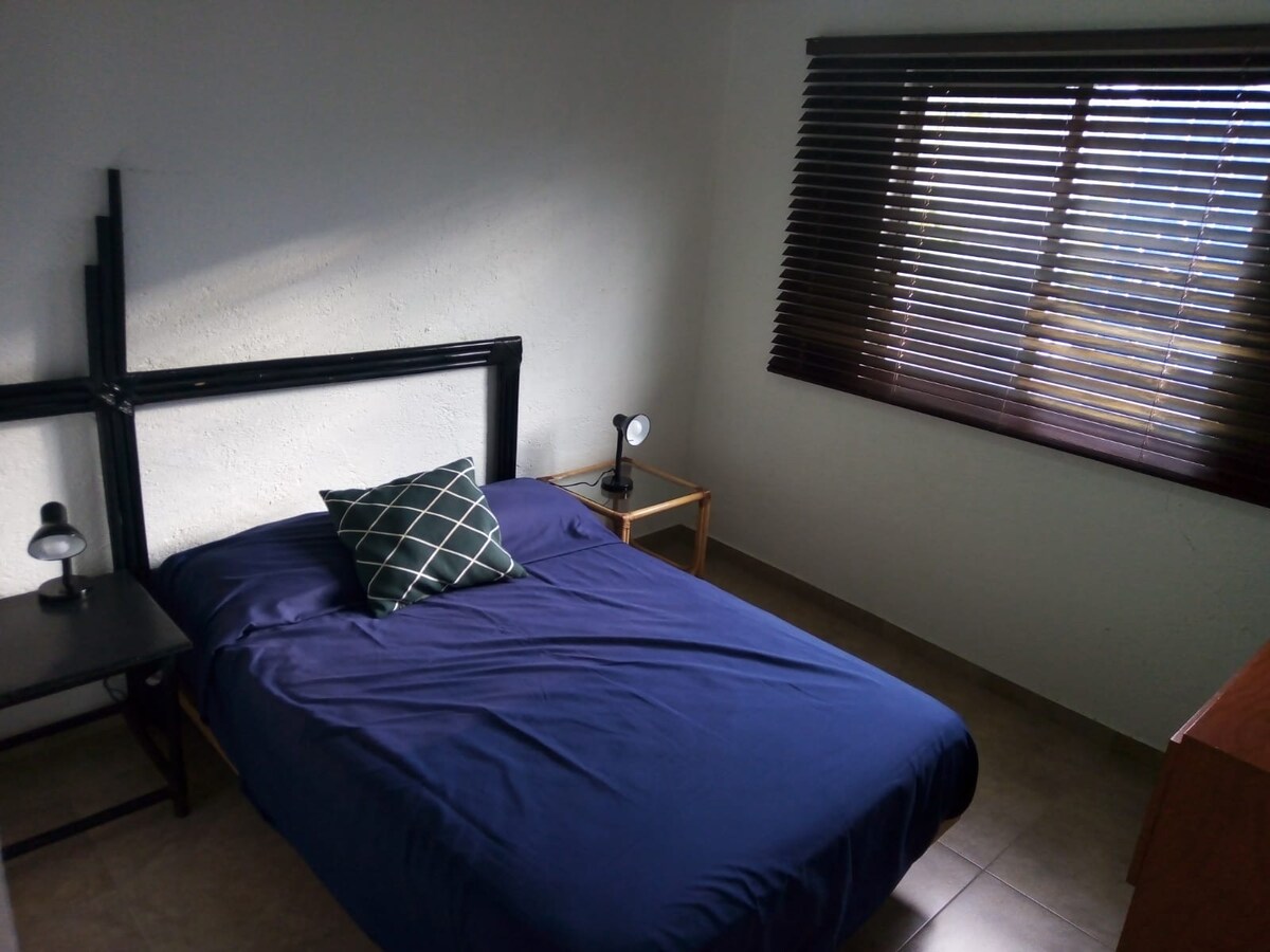 Recámara con cama matrimonial y escritorio