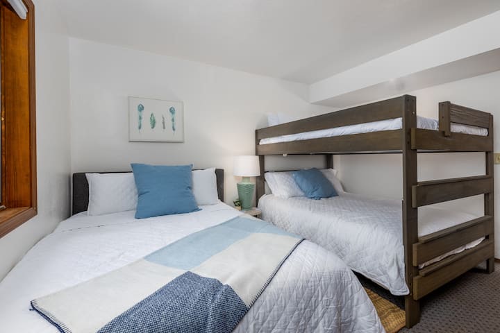 Downstairs bedroom with queen bed and queen over queen bunk bed.