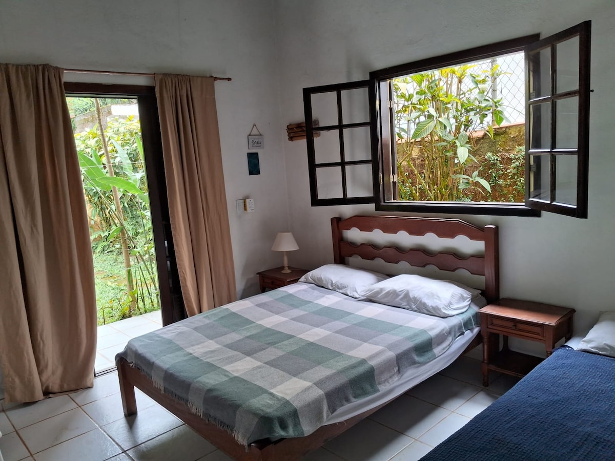 Suite 3, con 1 cama doble, 1 cama individual, armario (no se muestra en la foto) y soporte de mostrador para el balcón trasero y el patio trasero de la casa =)