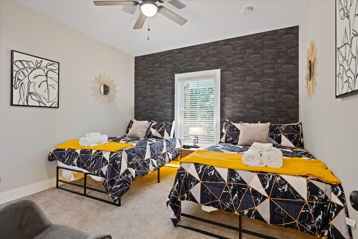 Განიტვირთეთ სტილი: ჩვენი საძინებელი ორი ორადგილიანი საწოლით და გასაოცარი ნაცრისფერი 3D ქვის კედლით, რომელიც აღჭურვილია ჯეკისა და ჯილის სააბაზანოსთან, ქმნის კომფორტის იდეალურ ოაზისს.