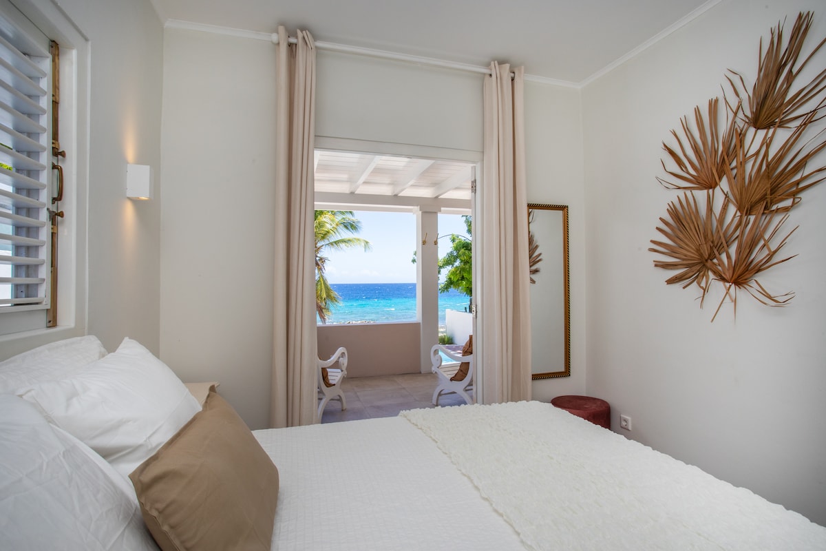 Bedroom on the sea side, with French doors and adjoining bathroom.