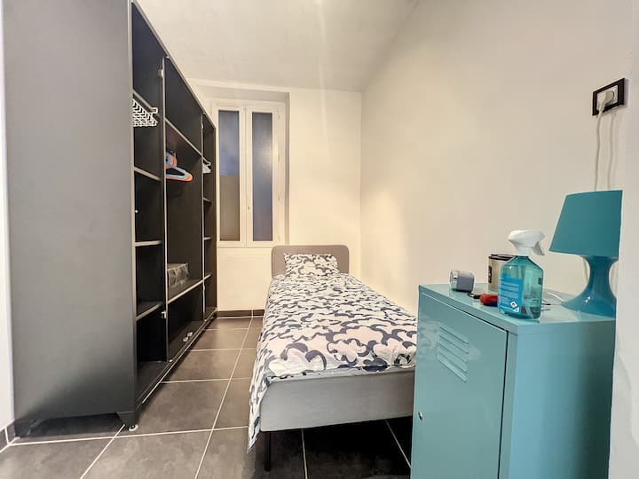 غرفة نوم بسرير مفرد ومساحات تخزين كبيرة.