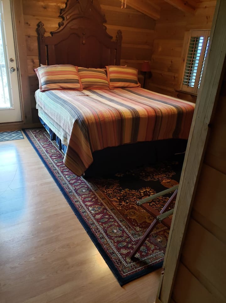 سرير بحجم كينغ في الطابق الثاني مقابل حمام كامل كبير.