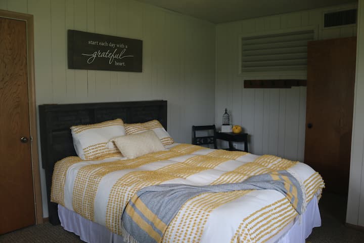 Cama tamaño queen con armario para colgar paños.