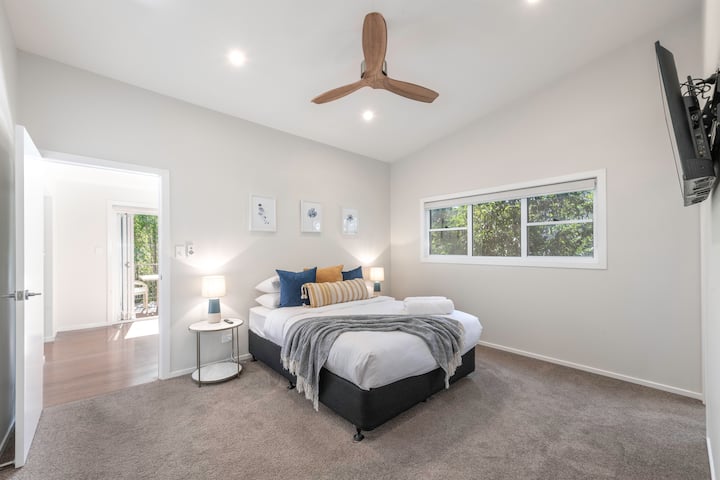 Მთავარი საძინებელი, ორადგილიანი საწოლი ვენტილატორით და კედელზე მიმაგრებული ტელევიზორით