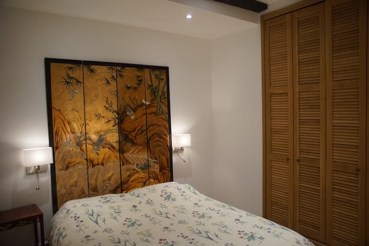 Quarto no piso térreo com cama de casal, armário e cômoda.