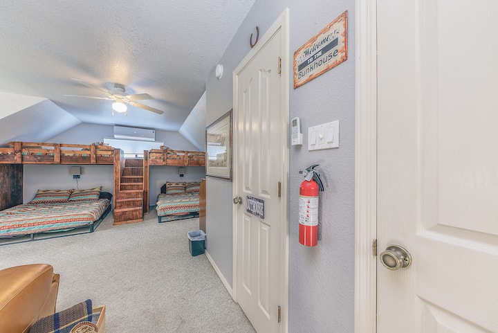 Cowboy Bunkhouse en el loft tiene 2 juegos de dos camas individuales sobre literas tamaño queen, calefacción y aire acondicionado mini-split, vestidor, ventilador de techo, televisor inteligente, sillas de cine, escritorio y baño privado. 