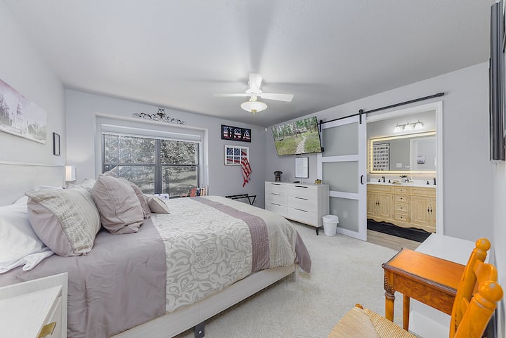 Suite Americana con cama king, ventilador de techo, TV inteligente y baño privado.