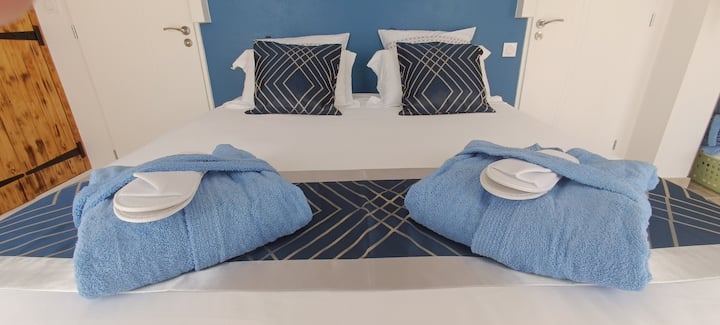 Cama de matrimonio, albornoces y zapatillas