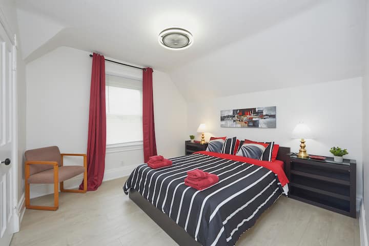 Cama tamaño queen en un dormitorio grande.  Esta habitación también tiene un armario grande para guardar la ropa. 