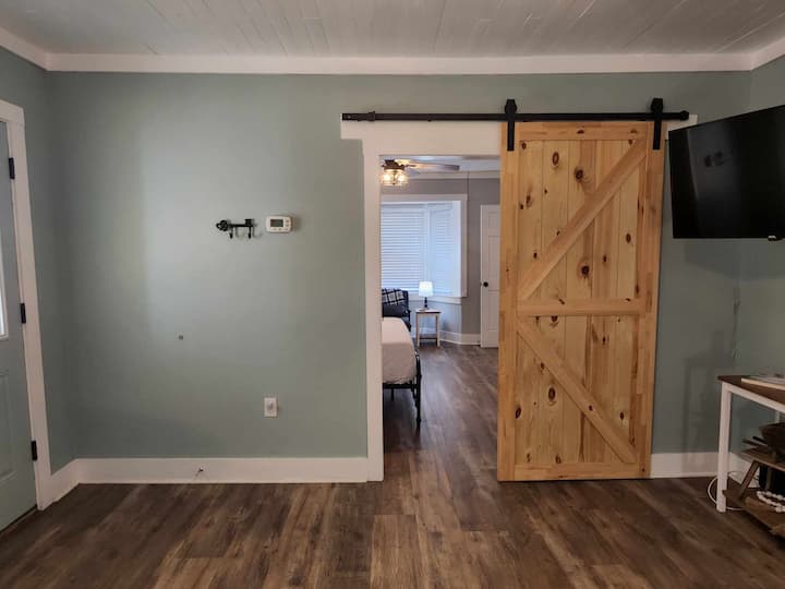 De voordeur in de woonkamer leidt naar het huis met de Master van de hoofdlevensruimte met een schuurdeur toegevoegd voor privacy. 