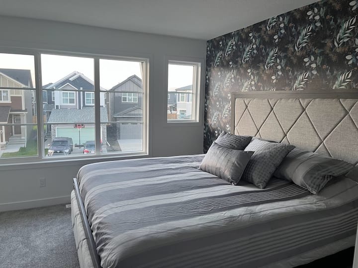 Dormitorio principal con colchón Serta de calidad del hotel, lámparas de lectura, silla de lectura, baño privado y vestidor con una ventana.