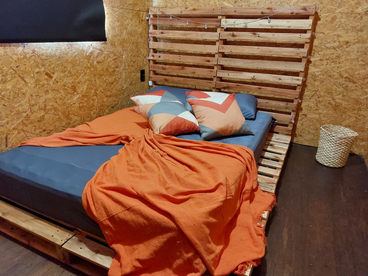 Narančasta soba, uređena u paletnom namještaju.