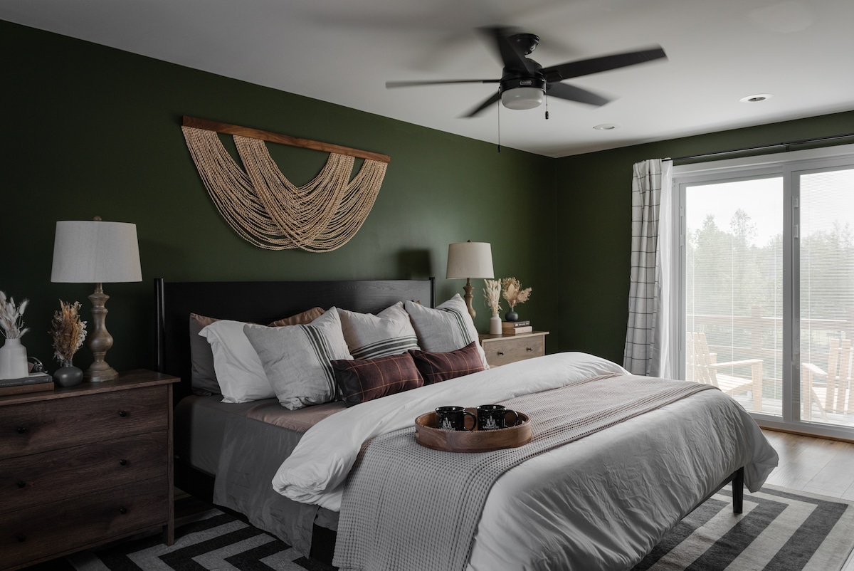 Pokojná spálňa s pokojnými zelenými tónmi a osviežujúcim stropným ventilátorom pre maximálne pohodlie.